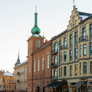 Historic buildings with ornate facades and green copper spires in central Oslo.
