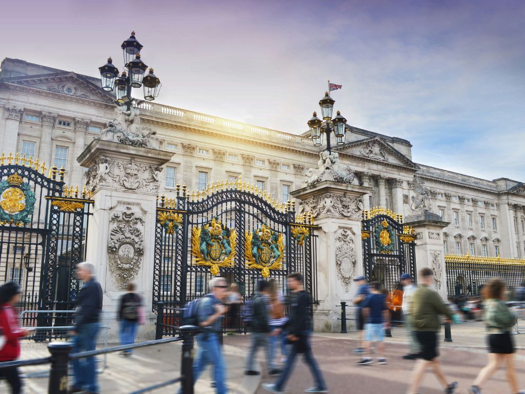 Travelers walking in front of Buckingham Palace in timelapse
