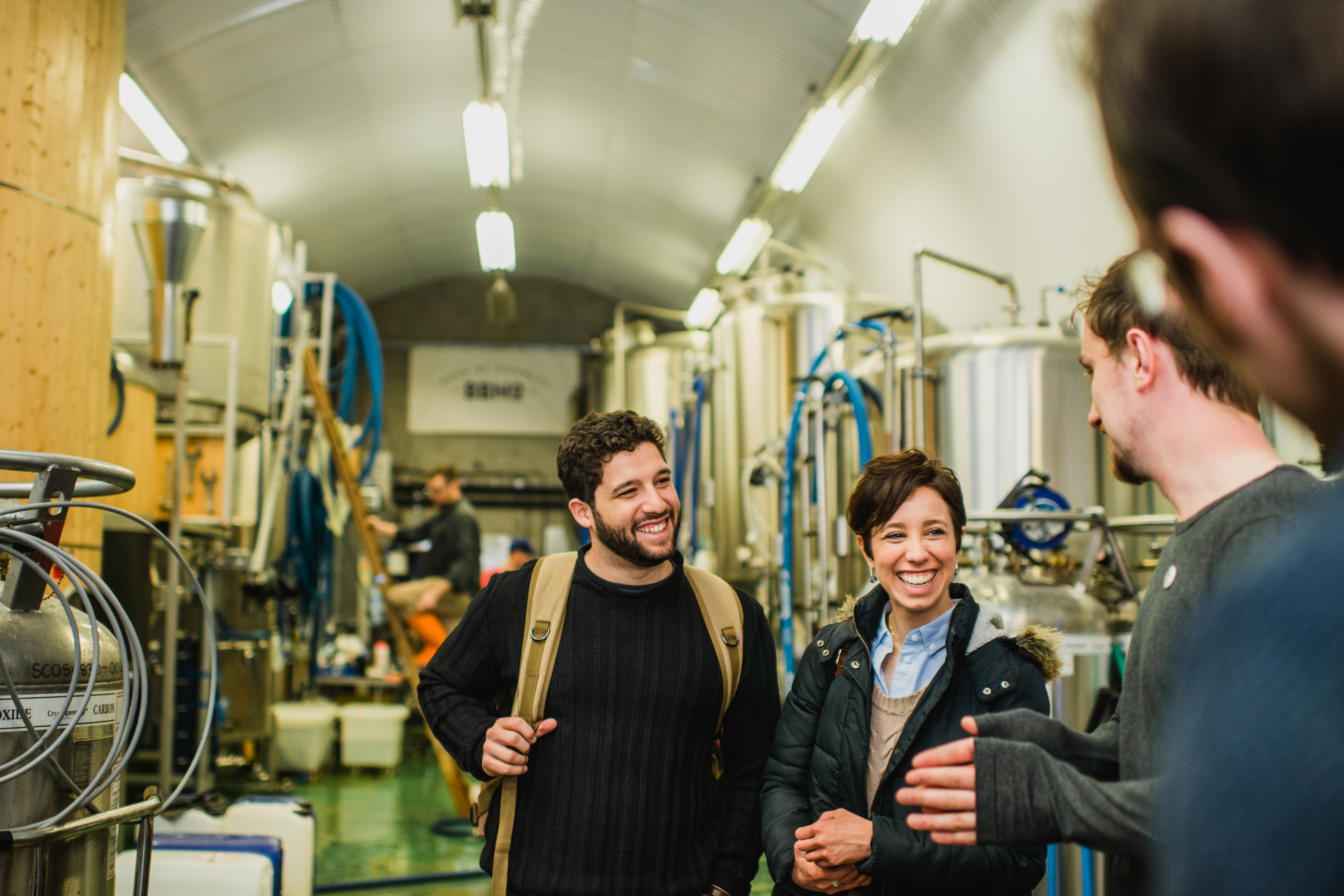 A couple smiling in a brewery on a Context London ale tour