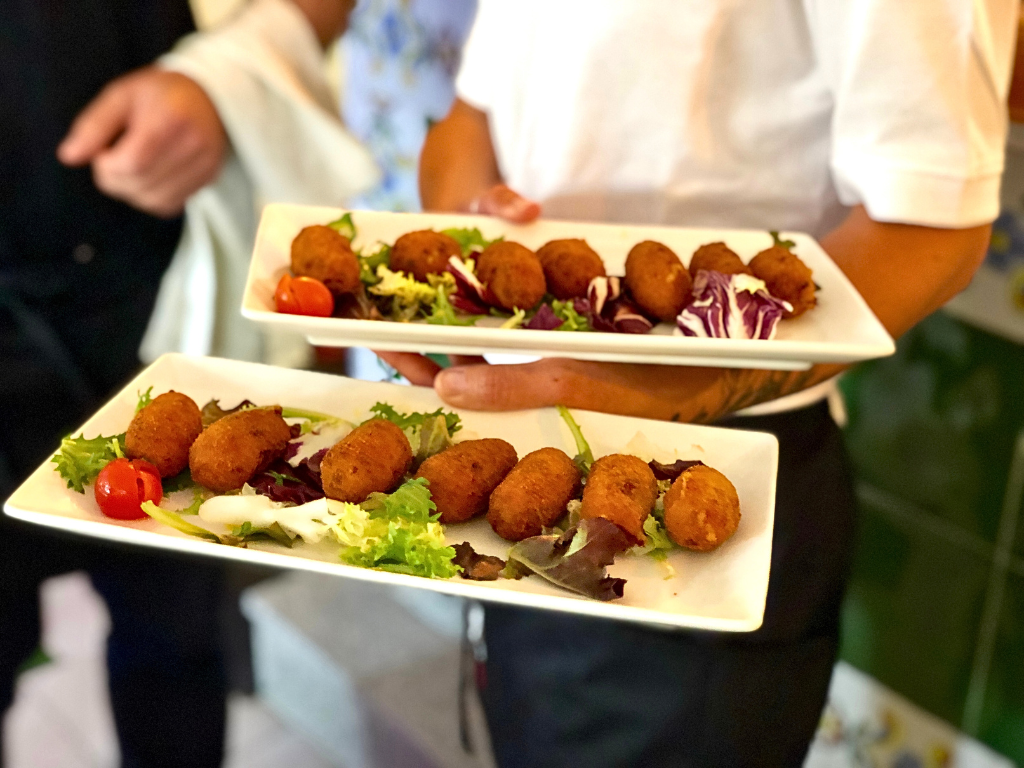 A waiter carrying croquettes